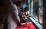 Le thérapeut Dennis Mandera s'occupe d'un jeune enfant atteint de handicap dans un centre spécialisé du bidonville de Mathare, le 8 septembre 2020 à Nairobi, au Kenya