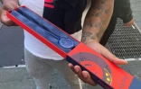Un client montre sa montre Audemars Piguet Swatch Royal Pop qu'il vient d'acheter devant une boutique Swatch à Time Square, le 16 mai 2026 à New York 
