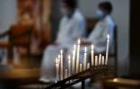 Sur cette photo d'illustration prise le 27 mars 2021, des bougies votives brûlent durant une messe à Brest, dans l'ouest de la France