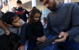Tareq al-Ennabi, un Palestinien de 25 ans, donne un cours d'anglais à des enfants déplacés dans une école devenue camp de déplacés à Rafah, dans le sud de la bande de Gaza, le 29 novembre 2023