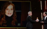Le directeur artistique de la Berlinale Carlo Chatrian (d) remet au réalisateur français Laurent Lariviere l'Ours d'or d'honneur décerné à Isabelle Huppert en vidéoconférence à Berlin le 15 février 2022