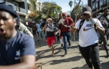 Des manifestants poursuivent des personnes qu'ils pensent être des étrangers en situation irrégulière, lors d'une manifestation organisée par les mouvements March and March et Operation Dudula, le 30 juin 2026à Johannesburg, en Afrique du Sud