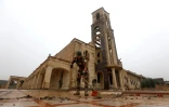 Un soldat irakien nettoie le parvis de l'église Saint John avant la messe de Noël à Qaraqosh, le 25 décembre 2016