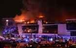 Des équipes de secours devant la salle de concert Crocus City Hall en flammes après une fusillade, le 22 mars 2024 à Krasnogorsk, dans la banlieue de Moscou