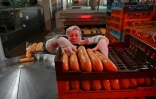 Une employée de l'usine de pain Tsar-Khlib près de Kiev empile les pains  le 25 mai 2022