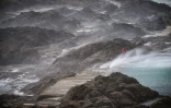 Des promeneurs s'abritent sur la grève de Saint-Malo, en Ille-et-Vilaine, pendant la tempête Austen, le 23 octobre 2026