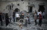 Des Palestiniens inspectent un immeuble détruit par une frappe israélienne à Deir al-Balah, dans le centre de la bande de Gaza, le 29 juillet 2026