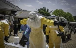 Des agents de santé sont aspergés de désinfectant après avoir été en contact avec le corps d'une personnes suspectée d'être morte de la maladie d'Ebola à Bunia, dans l'est de la République démocratique du Congo, le 25 mai 2026