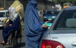 Une Afghane en burqa vend des masques de protection à un automobiliste dans une rue de Kaboul, le 5 septembre 2021