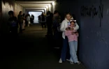 A Kiev, des passants s'abritent dans un passage souterrain pendant une alerte avertissant du danger de frappes russes, le 4 octobre 2026