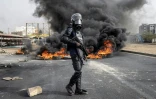Un gendarme sénégalais marche près d'un incendie provoqué par des manifestants, le 29 mai 2023 à Dakar