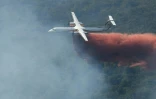 Un bombardier Dash de la Sécurité Civile largue du retardant  sur un incendie de forêt au nord de Grimaud, le 18 août 2021 dans le Var