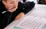 Un élève luxembourgeois apprend la calligraphie chinoise, lors d'une leçon de chinois dans son établissement à Luxembourg, le 7 octobre 2017