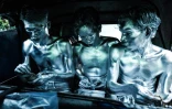 Les artistes de rue Keris Munandar (g), son frère Ari Munandar (c) et leur voisin Riyan Ahmad Fazriyansah (d), assis dans un tuk-tuk, comptent leurs gains après avoir fait la manche dans les rues à Jakarta, le 1er avril 2025 en Indonésie