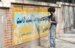 Un Iranien efface le 29 septembre 2019 une fresque murale peinte sur les murs de l'ambassade des Etats-Unis à Téhéran pour commémorer la prise d'otages du personnel diplomatique américain en 1979