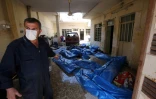 Un Irakien près des corps d'habitants du quartier d'al-Jadida tués lors d'un raid visant le groupe EI le 26 mars 2017 à Mossoul  