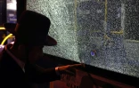 Un homme montre un impact de balle dans la fenêtre d'un bus après une attaque armée dans le centre de Jérusalem le 14 août 2022
