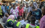 Des électeurs se plaignent auprès de représentants de la Commission électorale des retards dans le début du vote lors des élections générales, le 15 janvier 2026 à Kampala, en Ouganda