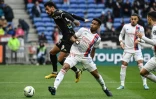 Le milieu de terrain brésilien de Lyon Thiago Mendes bouscule son homologue angevin Angelo Fulgini, lors de la 30e journée de Ligue 1, le 3 avril 2022 au Groupama Stadium à Decines-Charpieu