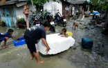 Des enfants jouent dans une rue inondée après le passage de la tempête Pabuk dans le sud de la Thaïlande, le 5 janvier 2019