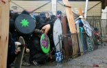 Des manifestants se protègent face aux forces de l'ordre à Santiago, le 22 novembre 2019