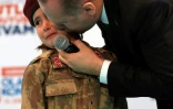 Cette photo, prise le 24 février 2018 et publiée le 28 février 2018 par le service de presse présidentiel turc, montre Recep Tayyip Erdogan embrassant Amine Tiras, une petite fille de 6 ans en treillis militaire, à Kahramanmaras