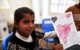Nora, une fillette irakienne qui a fui les combats à Mossoul montre le dessin qu'elle a fait au camp de Hasan Sham situé à 30 km à l'est de Mossoul, le 31 mars 2017