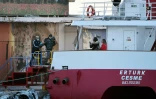 Un migrant est embarqué par encadré par des membres de l'agence Frontex pour être renvoyé en Turquie le 4 avril 2016 dans le port de Chios en Grèce