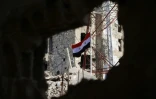 Un drapeau syrien flotte sur un bâtiment de la province de Deraa dans le sud de la Syrie le 12 juillet 2018