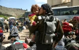 Un combattant rebelle de la Ghouta orientale embrasse un enfant qui vient d'arriver dans le village de Qalaat al-Madiq, Ă 45 km au nord-ouest de la ville centrale de Hama le 31 mars 2018