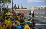 Des Thaïlandais attendent près du Grand palais le passage de la grande parade pour le couronnement du roi Maha Vajiralongkorn dans les rues de Bangkok, le 5 mai 2019