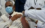 Le ministre ivoirien de la Santé, Eugène Aka Ouélé reçoit une injection de vaccin AstraZeneca/Oxford contre le Covid-19, reçues grâce au dispositif Covax, à Abidjan le 1er mars 2021