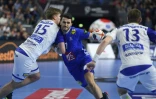 Le Français Ludovic Fabregas (c) à la lutte avec l'Islandais Daniel Thor Ingason (g) au Mondial de handball, le 20 janvier 2019 à Cologne
