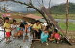 Une famille dont la maison a été détruite par le typhon Rai, le 24 décembre 2021 à Surigao City, aux Philippines