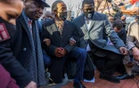 L'avocat Ben Crump, le révérend Al Sharpton et des membres de la famille de George Floyd, agenouillés en sa mémoire le 29 mars 2021 à Minneapolis