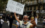 Un homme prend un selfie en tenant une pancarte lors d'une manifestation contre la vaccination obligatoire contre le Covid-19 pour certains travailleurs à Paris le 21 août 2021