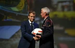 Le président français Emmanuel Macron (g) reçoit un casque de pompier des mains du président des sapeurs-pompiers de France Grégory Allione durant la cérémonie de clôture du 127e Congrès national des sapeurs-pompiers de France à Marseille, le 16 octobre 2021