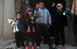 Des enfants vont le signe de la victoire après l'entrée des forces irakiennes dans un quartier sud de Mossoul, le 24 février 2017