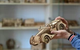 Un employé tient une maquette de voiture en bois fabriquée à l'usine Ugears, le 6 juin 2022 à Gorenka, au nord de Kiev, en Ukraine