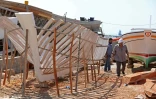 Des membres de la famille syrienne des Bahlawan aident à la construction d'un bateau en bois au bord de l'île d'Arwad, dans l'ouest de la Syrie, le 24 juillet 2022