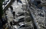 Des Casques blancs syriens et des membres des forces de sécurité sur le site d'une frappe aérienne israélienne à Damas, le 13 mars 2025