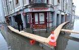 Un homme marche sur des planches dans une rue inondée après que la Vilaine soit sortie de son lit à Redon, en Ille-et-vilaine, le 29 janvier 2025