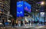 Des écrans d'indices boursiers dans une rue de Shanghai, le 7 avril 2025