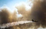Un avion bombardier d'eau effectue un largage sur les feux de forêt près de Monchique, dans la région de l'Algarve, sud du Portugal, le 8 août 2018
