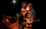 Une femme et des enfants arrivent sur l'île grecque de Lesbos après avoir traversé la mer Egée depuis la Turquie, le 27 octobre 2015