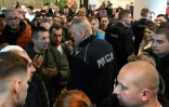 Des policiers polonais s'entretiennent avec des Ukrainiens rassemblés devant un bureau de délivrance de passeports ukrainiens fermé à Varsovie, le 24 avril 2024