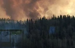 De la fumée s'élève au dessus de la ville de Fort McMurray ravagée le 3 mai 2016 par un incendie
