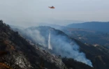 Un hélicoptère lâche de l'eau sur les collines de Toro Canyon, au nord de Santa Barbara, en Californie, le 12 décembre 2017