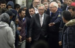 Le président de la Commission européenne Jean-Claude Juncker entouré par des migrants lors d'une visite au centre d'enregistrement de Passau, en Allemagne, le 8 octobre 2015
