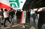 Des Irakiens manifestent dans la capitale irakienne Bagdad brandissant un gigantesque drapeau, le 26 décembre 2019